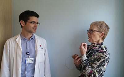 Angela Burlton utilise son larynx artificiel pour parler avec son orthophoniste, Jesse Burns.