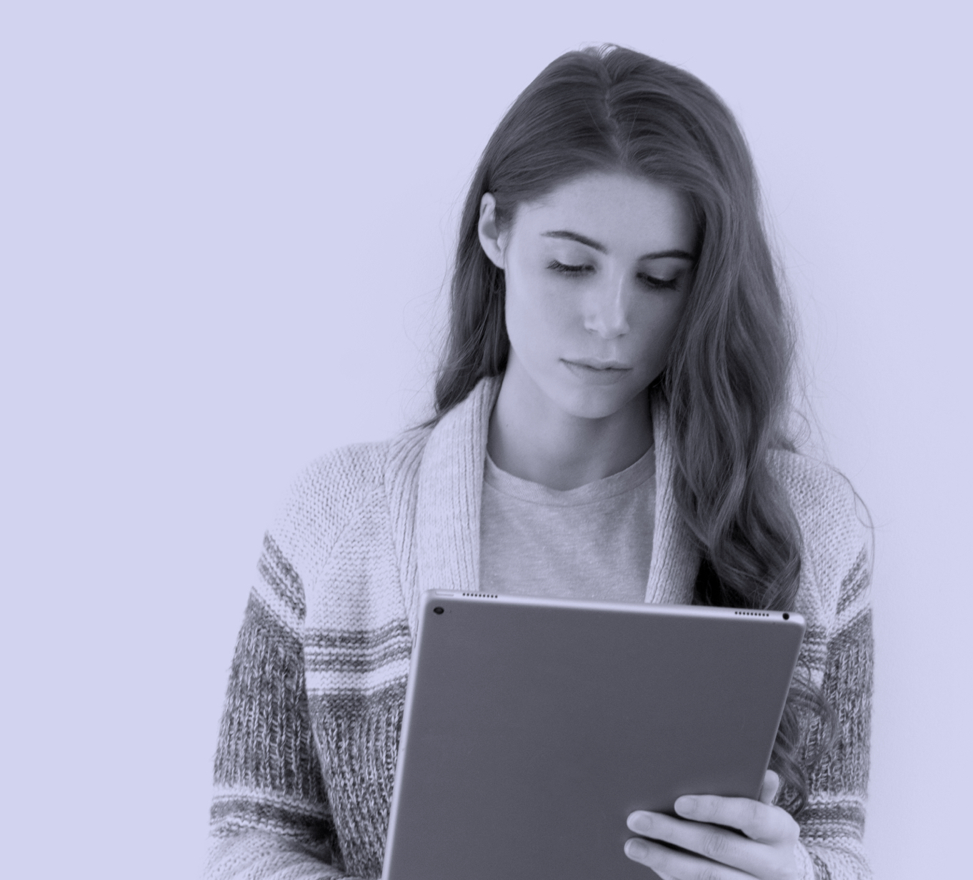Une jeune femme lis sur une tablette électronique.